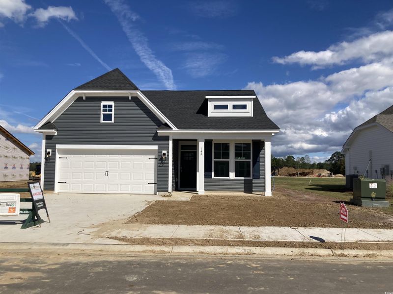 View of front of house with a shingled roof, concrete driveway, a garage, and a porch