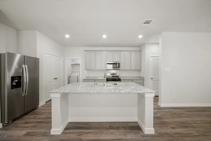 A kitchen with a marble counter.