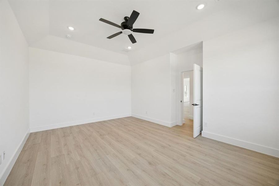 Unfurnished room with light wood-type flooring, recessed lighting, ceiling fan, and a tray ceiling Unfurnished room with light wood-type flooring, recessed lighting, ceiling fan, and a tray ceiling