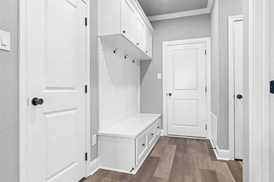 Mudroom with ornamental molding, dark wood-type flooring, and visible vents Mudroom with ornamental molding, dark wood-type flooring, and visible vents