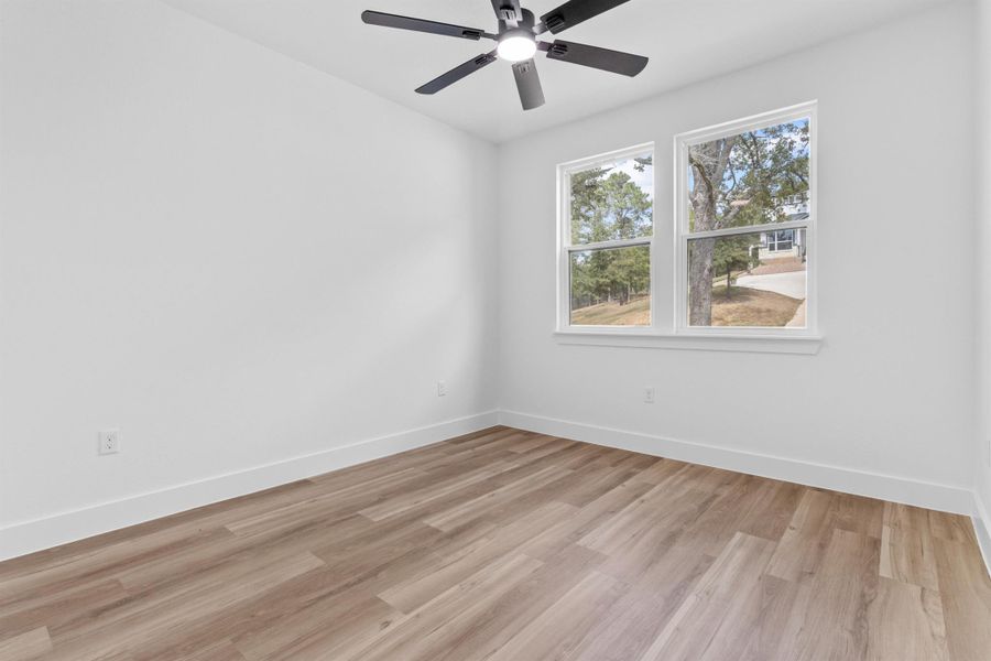 Unfurnished room featuring light wood-style floors and ceiling fan