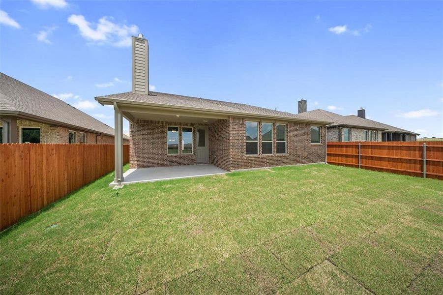 Rear view of property featuring a chimney, brick siding, and a patio area