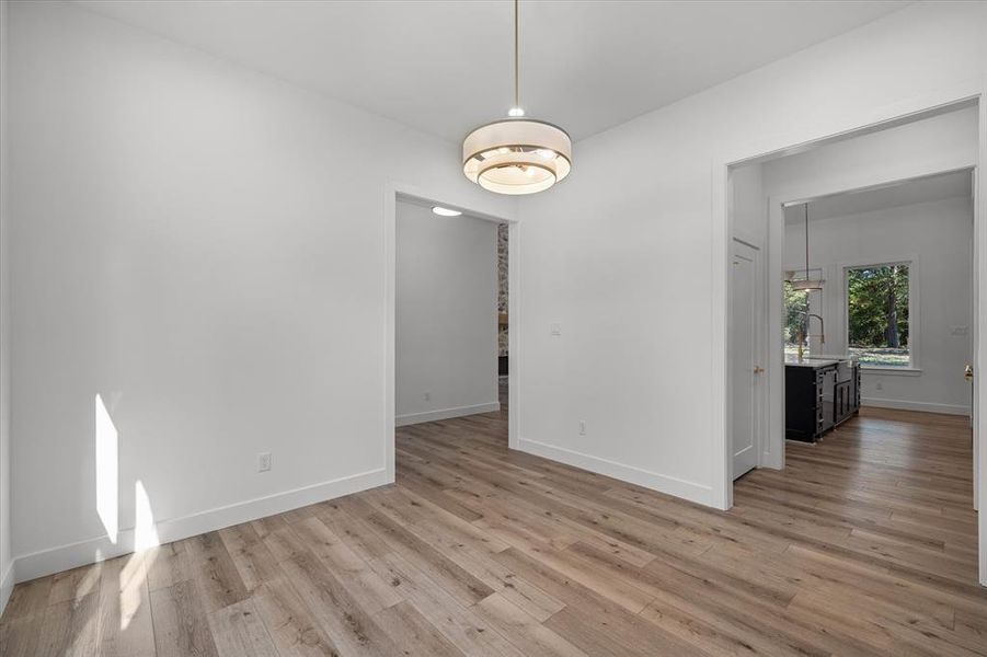 Unfurnished dining area with light wood finished floors and baseboards