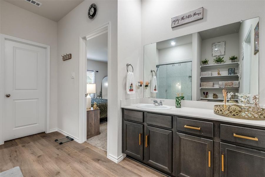 Bathroom with connected bathroom, a stall shower, vanity, and light wood finished floors Bathroom with connected bathroom, a stall shower, vanity, and light wood finished floors