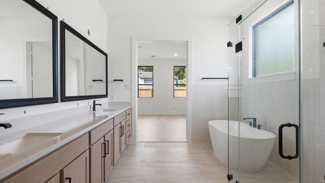 Primary bathroom with a glass-enclosed standing shower and separate soaking tub.