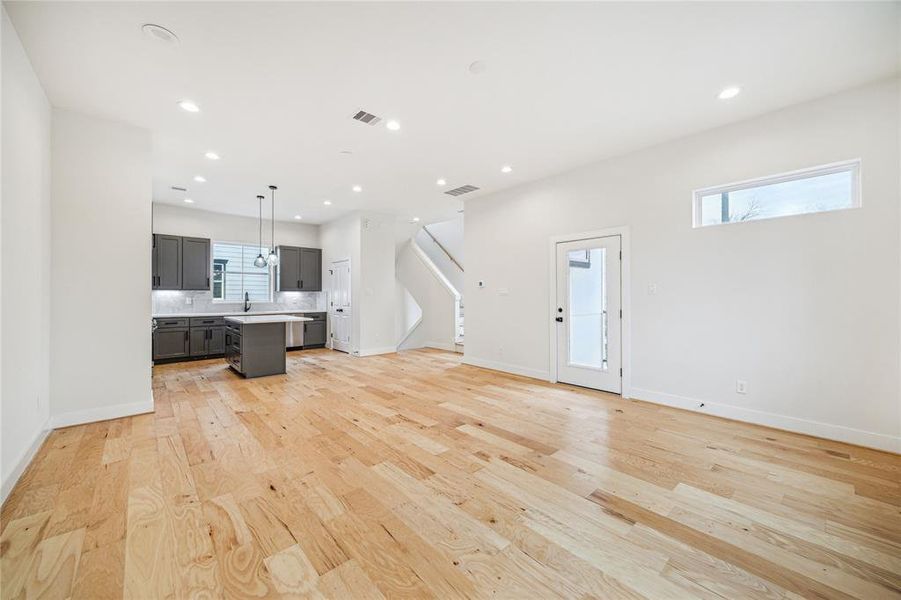 Bright and open living area seamlessly flows into the dining space and modern kitchen, featuring sleek cabinetry and elegant finishes.