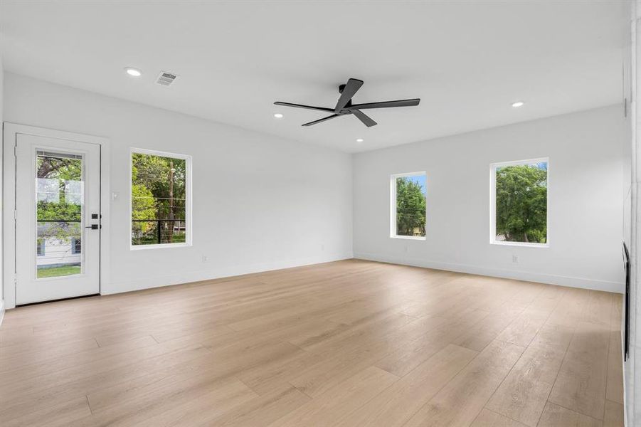 Spare room with a healthy amount of sunlight, light wood finished floors, and ceiling fan