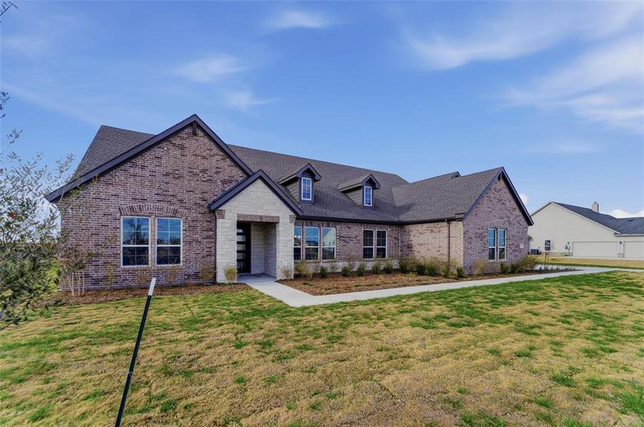 View of front of house featuring brick siding and a front yard