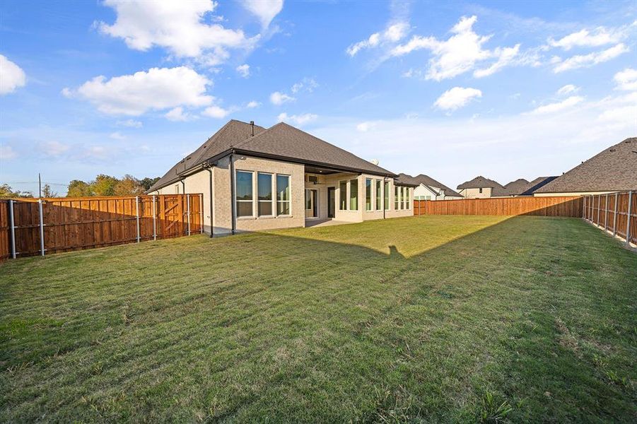 Back of property with a patio, a fenced backyard, a shingled roof, and brick siding Back of property with a patio, a fenced backyard, a shingled roof, and brick siding
