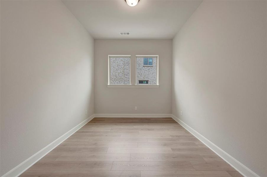 Empty room featuring light wood-style flooring and baseboards