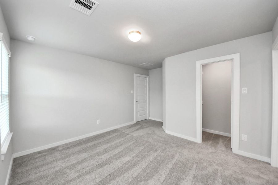 Secondary bedroom features plush carpeting, large windows that let in plenty of natural light, bright paint, and spacious closets. Sample photo of completed home with similar floor plan. Actual colors and selections may vary. Secondary bedroom features plush carpeting, large windows that let in plenty of natural light, bright paint, and spacious closets. Sample photo of completed home with similar floor plan. Actual colors and selections may vary.