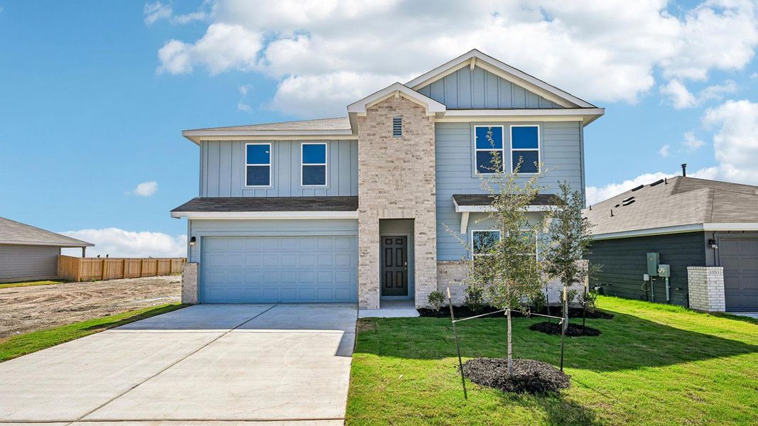 Front exterior of a new home in Carillon, Manor, TX, highlighting curb appeal (Image 2).