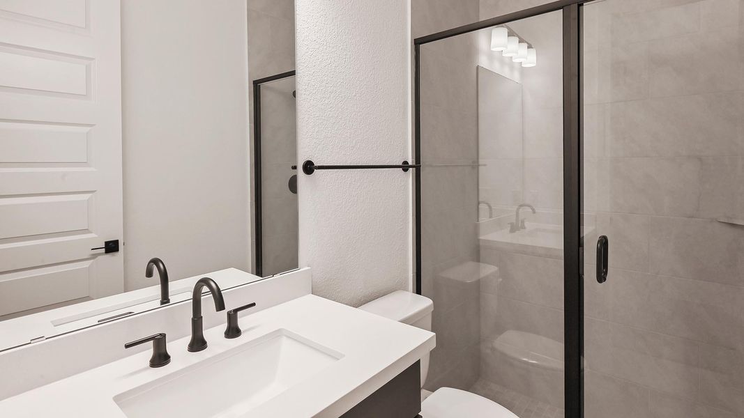 Unfurnished living room featuring ceiling fan, a tiled fireplace, wood finished floors, a chandelier, and baseboards