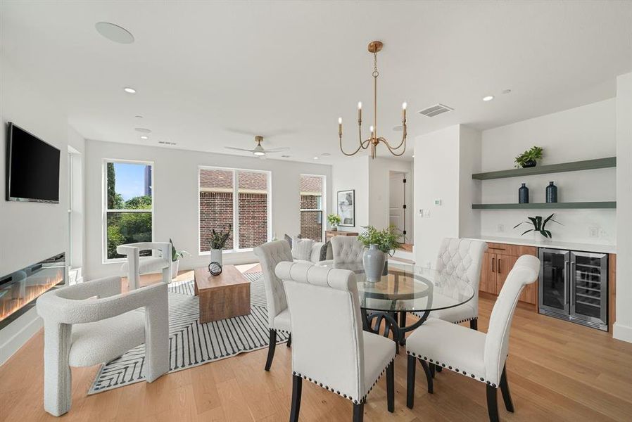Open-concept living area featuring light wood-finish flooring, recessed lighting, and a modern linear fireplace Open-concept living area featuring light wood-finish flooring, recessed lighting, and a modern linear fireplace