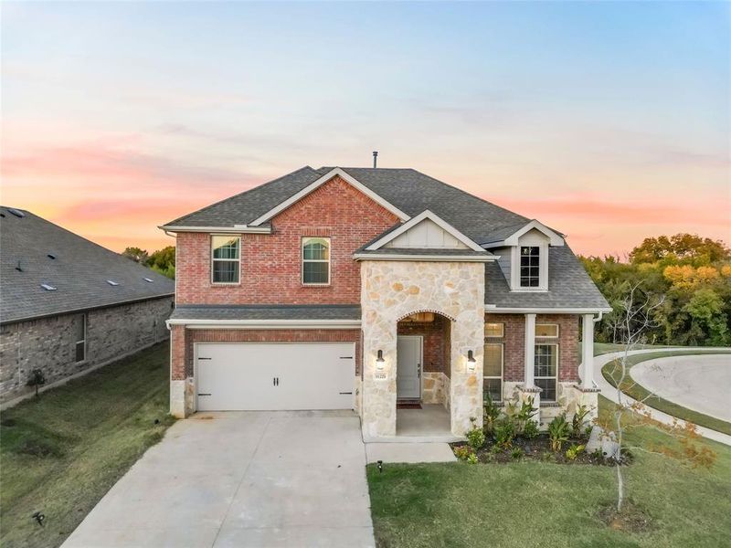 View of front of home with a porch, a garage, and a yard