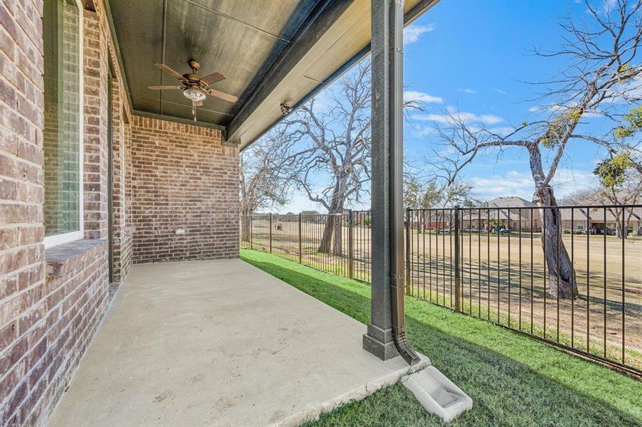 Fenced backyard featuring a ceiling fan and a patio