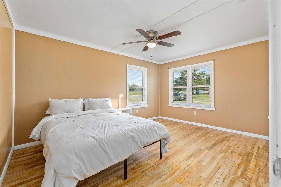Bedroom featuring light wood finished floors, ceiling fan, and crown molding Bedroom featuring light wood finished floors, ceiling fan, and crown molding
