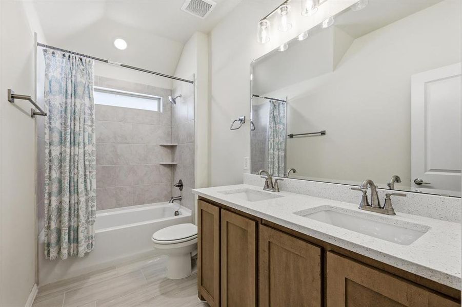 Bathroom featuring a double vanity with light-colored countertops, dual undermount sinks, and brushed nickel hardware