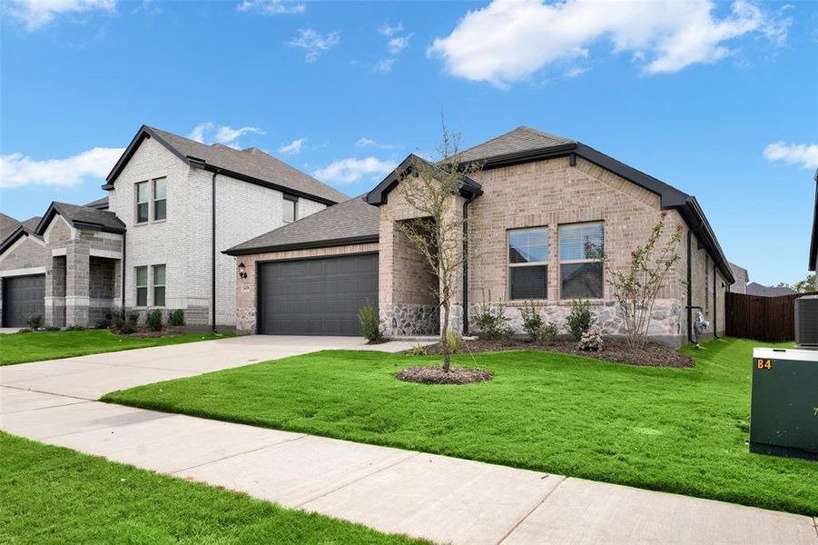 View of front facade with brick siding, driveway, a garage, and roof with shingles View of front facade with brick siding, driveway, a garage, and roof with shingles