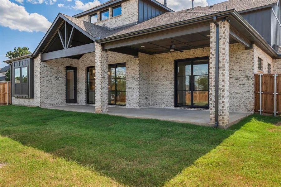 Back of house with a patio area, ceiling fan, and a yard