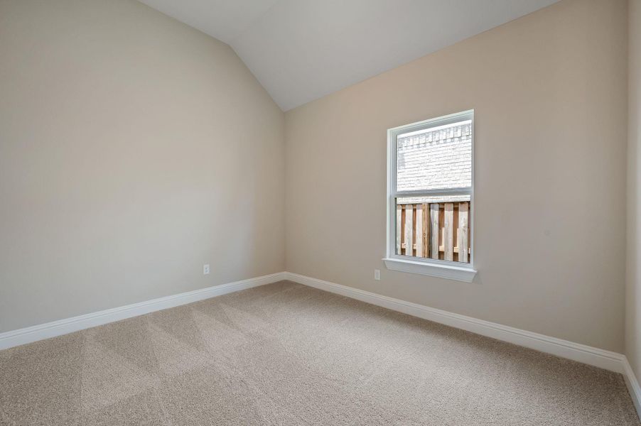 Unfurnished room featuring carpet flooring and vaulted ceiling