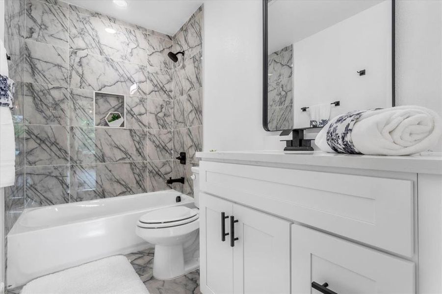 Full bathroom featuring tile patterned flooring, toilet, tiled shower / bath, and vanity