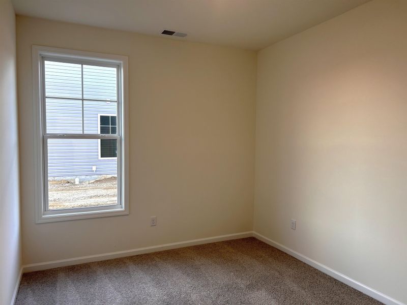 Carpeted spare room featuring baseboards