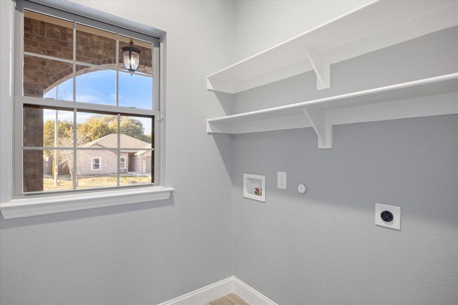 Laundry area featuring electric dryer hookup, washer hookup, and a wealth of natural light