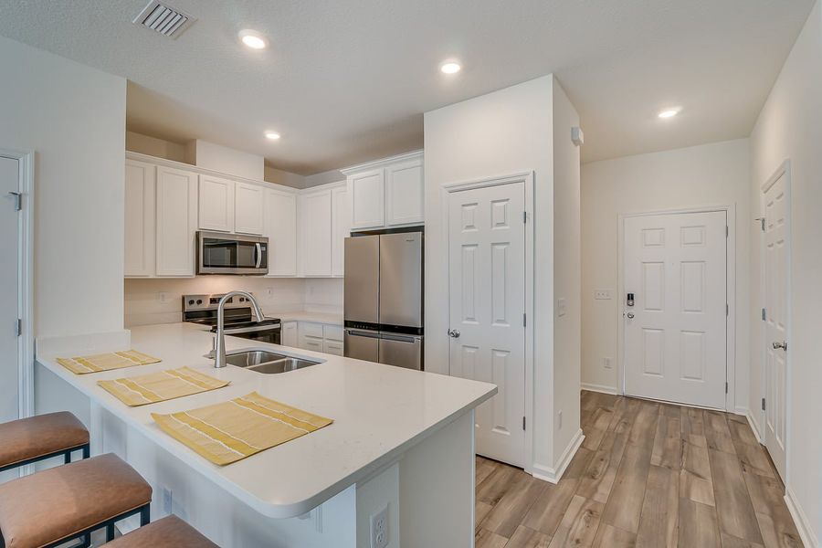 Furnished interior in a model home at Orchard Park Townhomes in St. Augustine (Image 10).