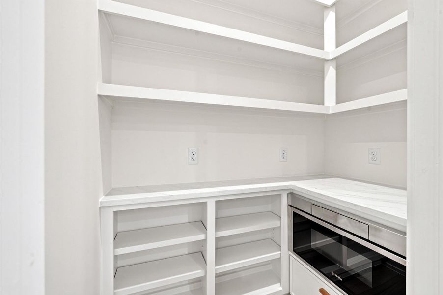 Walk-in pantry with microwave.