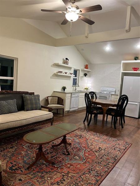 Vaulted ceiling with exposed beams and a ceiling fan