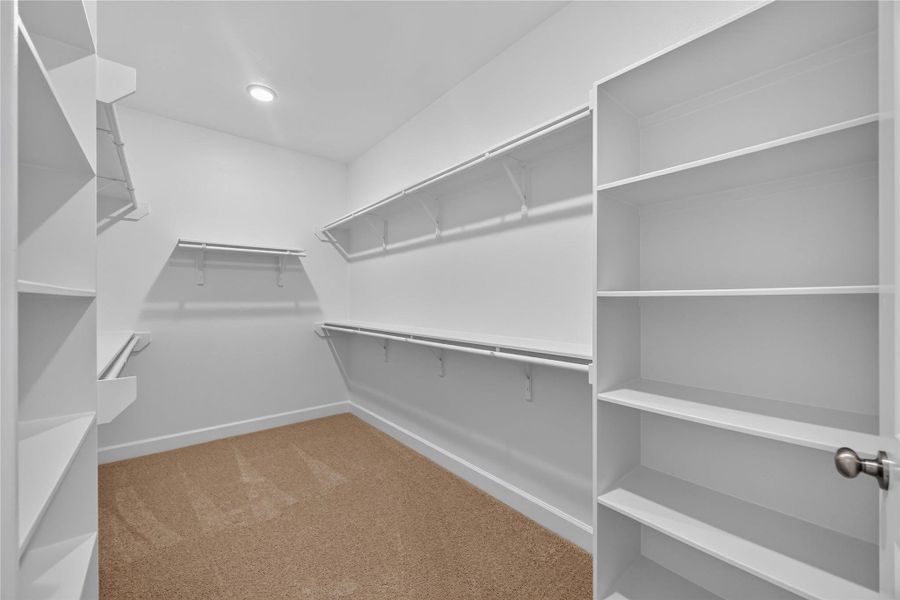 Primary Walk-In Closet – An expansive closet with built-in shelving and rods offers all the storage you need for an organized lifestyle.