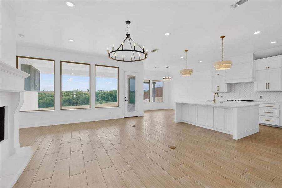 Spacious open-concept interior featuring light wood-finish flooring and a white color palette Spacious open-concept interior featuring light wood-finish flooring and a white color palette