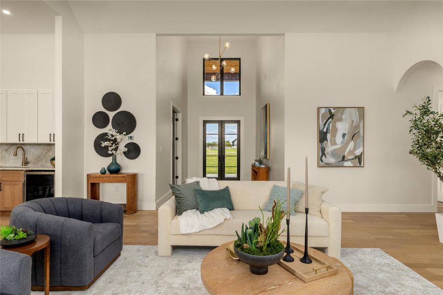Living area with light wood-style flooring and a high ceiling