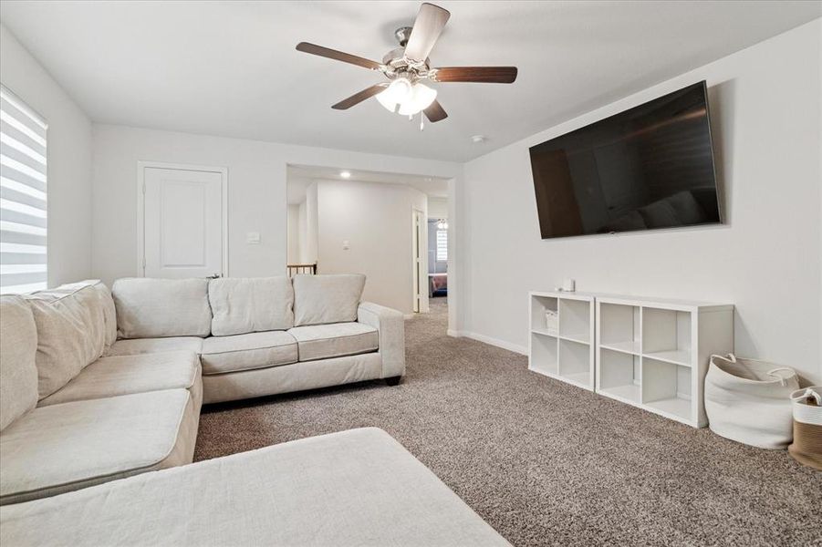 Living room with carpet and a ceiling fan Living room with carpet and a ceiling fan