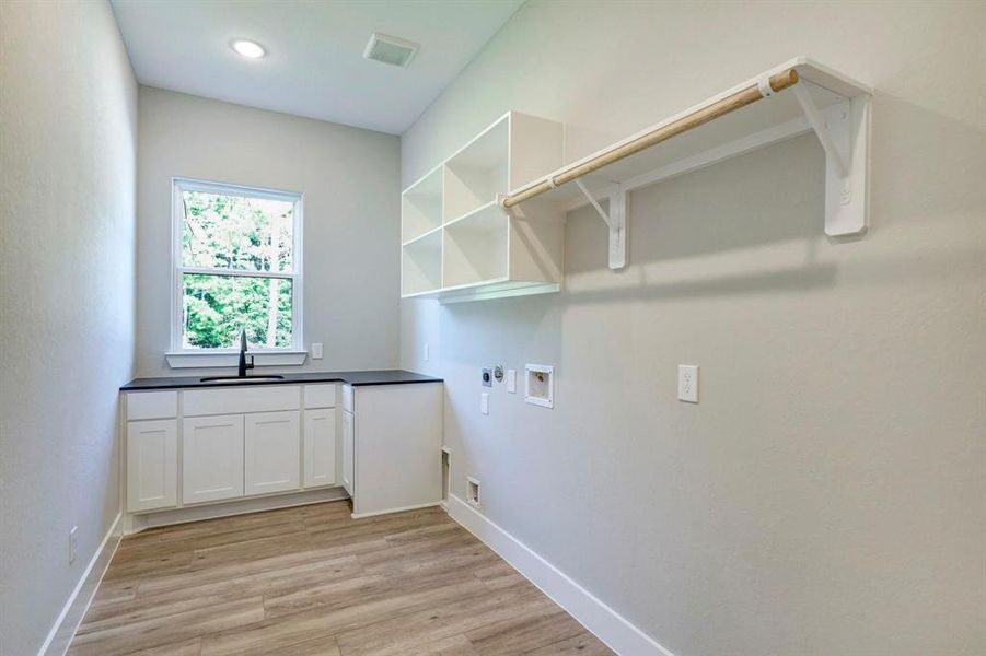 This well-appointed laundry space includes ample storage, additional sink and efficient organization, making laundry day a breeze while keeping your home tidy and functional.