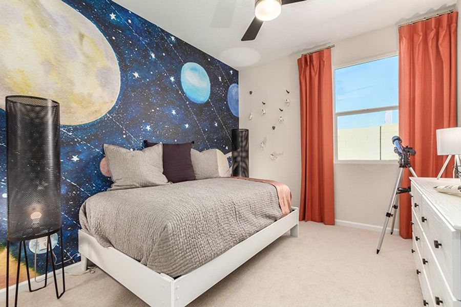 A bedroom with a bed and a large blue wall. A bedroom with a bed and a large blue wall.
