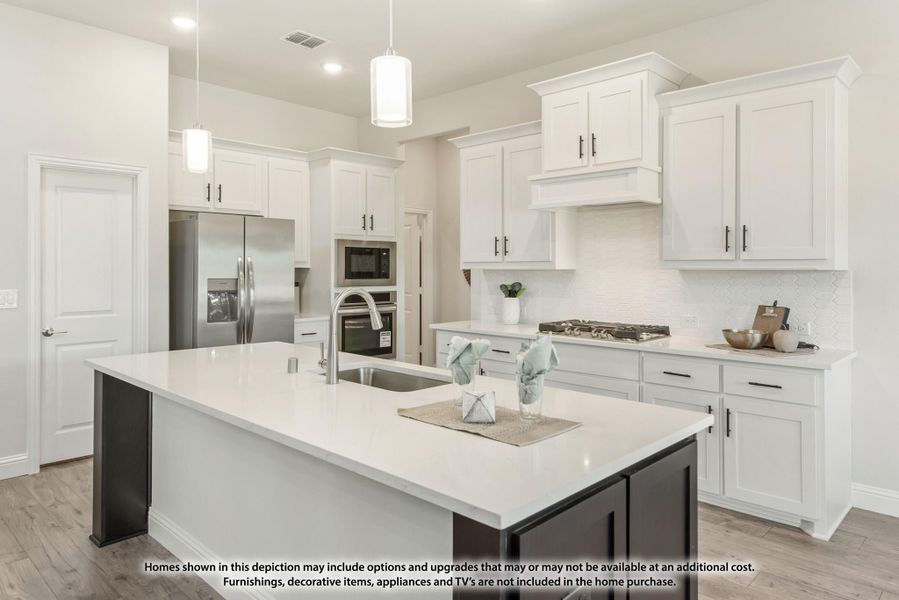 Kitchen with white cabinets, large dark island, quartz countertops, stainless appliances, and pendant lights