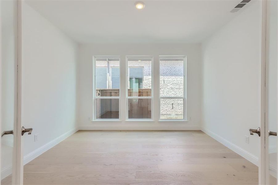 Empty room with wood-type flooring, plenty of natural light, and french doors