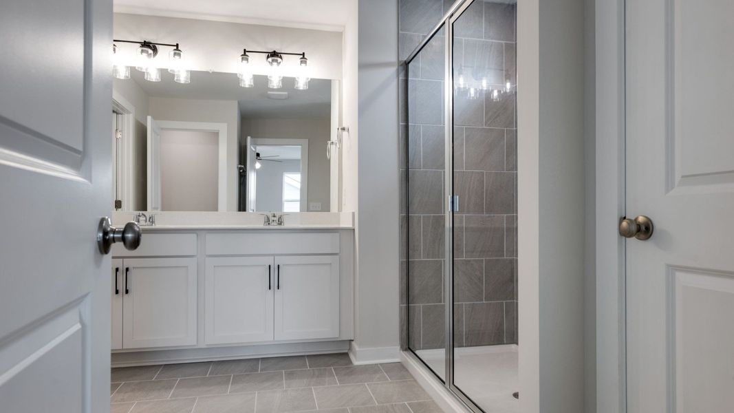 Primary bathroom with dual sinks and roman shower