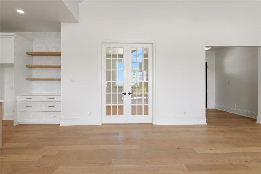 A home office is tucked behind double French doors that open to the main living space. A home office is tucked behind double French doors that open to the main living space.