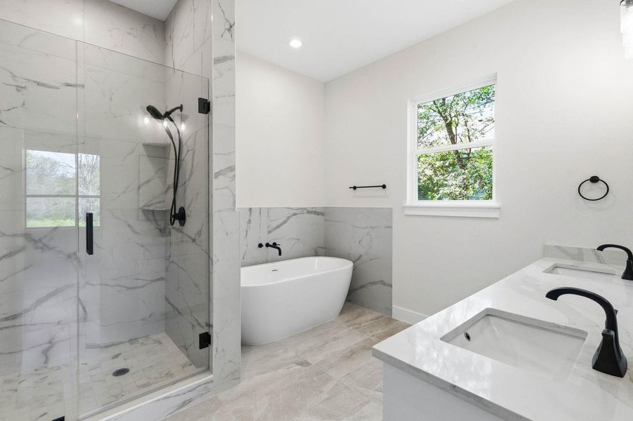 Luxurious bathing quarters feature a freestanding tub, sleek dual vanities, and a spacious glass-enclosed shower. Luxurious bathing quarters feature a freestanding tub, sleek dual vanities, and a spacious glass-enclosed shower.