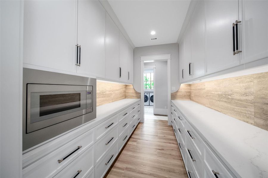 The butlers pantry is a true masterpiece.  It is designed to provide ample storage as well as a prep space for servers when entertaining guests. The accent stone work is unique with a beautiful natural color and texture.
