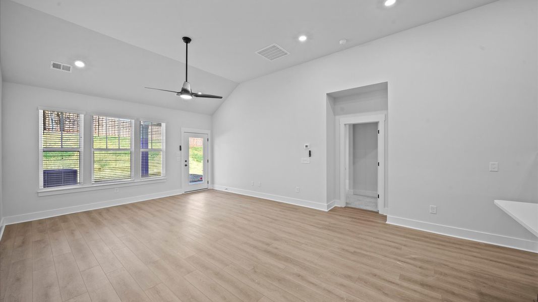 Spacious and stylish family room with two-story ceilings that create a bright and open atmosphere