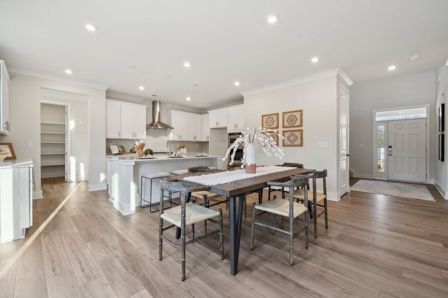 A kitchen with a dining table and chairs.