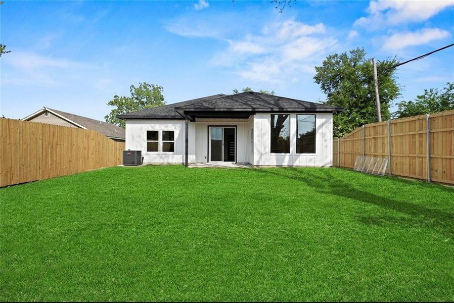 Back of house featuring a patio area, a fenced backyard, and a shingled roof