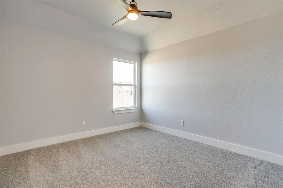 Unfurnished room featuring carpet flooring and a ceiling fan