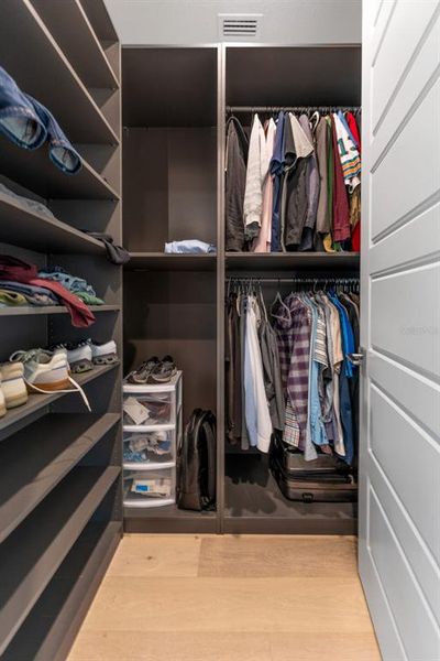 1 of 2 primary bedroom closets with custom shelving 1 of 2 primary bedroom closets with custom shelving