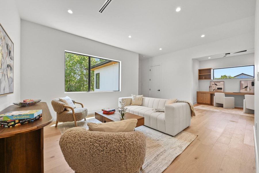 Living room featuring built in study area, recessed lighting, light wood-type flooring, and healthy amount of natural light