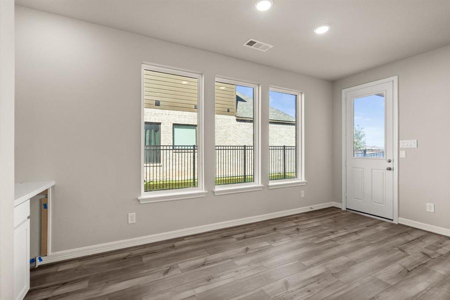 With an abundance of natural light streaming through the windows, the breakfast nook is bathed in a sunny glow, creating the perfect atmosphere to enjoy your morning coffee or a family breakfast.